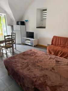 a living room with a bed and a couch at Tornac, La Madeleine in Tornac