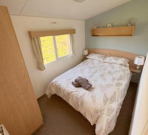 a small bedroom with a bed and a window at 609 Sycamore Forest in Newquay
