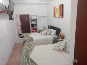 a small bedroom with two beds and a window at Rinconcito Veracruzano in Veracruz