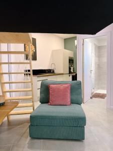 a living room with a green couch with a red pillow at Le Studio de l 'Avenue 1 à 3 Personnes in Valence
