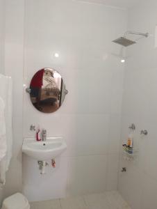 a white bathroom with a sink and a mirror at Rinconcito Veracruzano in Veracruz