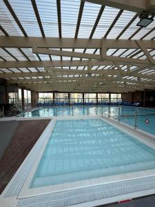 a large swimming pool with a large amount of water at Sunset suite - step from the beach in Ashkelon
