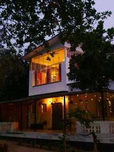 a house is lit up at night at Dheer- BnB at an Artist's Abode in Shānti Niketan +27 photos