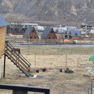 a group of houses in a field with a horse at mood villa kazbegi in Kazbegi