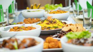 a table with many plates of food on it at Dhanora Dynasty Resort in Anuradhapura