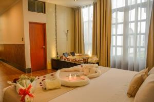 a bedroom with a large bed with candles on it at Hotel Anddari in Arequipa