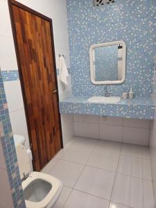 a bathroom with a toilet and a sink and a mirror at Flat 02 Carvalhos de Aldeia in Recife
