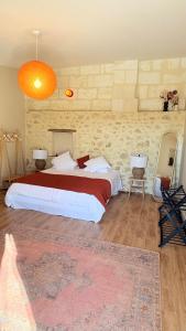 a bedroom with a large bed and a brick wall at Château Clos des Maurins in Vérac