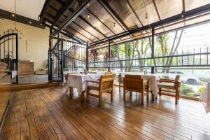 a dining room with tables and chairs and a large window at Hotel Du Parc in Medellín