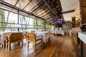 a restaurant with white tables and chairs and a tv at Hotel Du Parc in Medellín