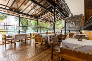 a restaurant with white tables and chairs and windows at Hotel Du Parc in Medellín