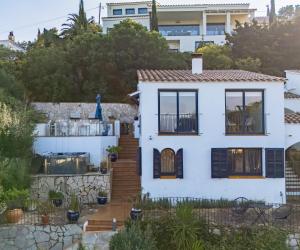 a white house with a garden and stairs at CASA CHAGUIMAMA Begur in Begur