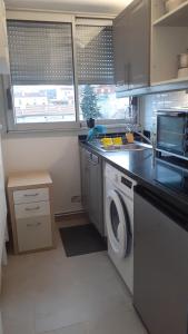a kitchen with a washing machine and a sink at LePré Apartment 93 in Le Pré-Saint-Gervais
