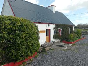 a small white building with a black roof at Historic old Cottage Co Mayo in Ballinrobe