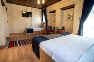 a bedroom with two beds and a tv in it at Levissi boutique hotel in Gaziantep