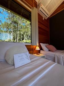 a bedroom with two beds and a window with trees at Quinta Terra Sagrada in Urubici +62 photos