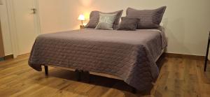 a bedroom with a large bed with gray sheets and pillows at Depto Zona Güemes Mdp in Mar del Plata