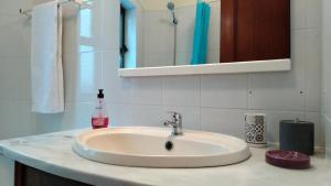a bathroom counter with a sink and a mirror at Luz de Cacilhas Apt, few steps away from Lisboa! in Almada +35 photos