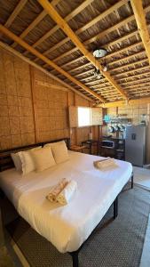 a large bed with two towels on it in a room at Salty Sun Cabins Bahía Turquesa in La Ventana