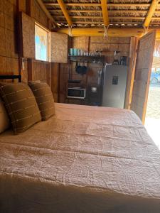 a large bed in a room with a kitchen at Salty Sun Cabins Bahía Turquesa in La Ventana