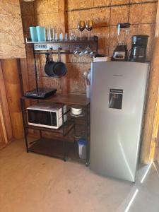 a kitchen with a refrigerator and a microwave at Salty Sun Cabins Bahía Turquesa in La Ventana +26 photos