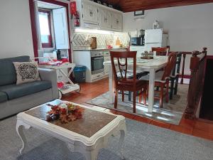 a living room with a couch and a table and a kitchen at Casa do Progo in Ponte de Lima