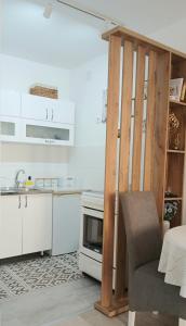 a kitchen with white cabinets and a chair in it at Studio Arija -na par koraka od PARKA - Banja Koviljača in Banja Koviljača +16 photos