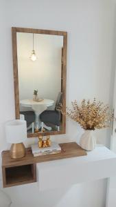 a mirror on a shelf with a lamp and a table at Studio Arija -na par koraka od PARKA - Banja Koviljača in Banja Koviljača