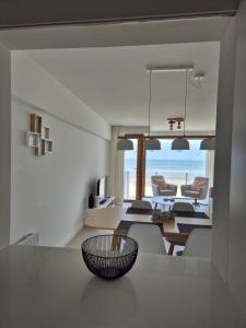 a dining room and living room with a view of the ocean at Alpha 503 in De Panne