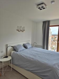a bedroom with a large bed with a window at Alpha 503 in De Panne