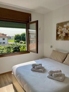 a bedroom with a bed with two towels on it at Cecia's House in Bassano del Grappa
