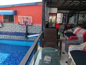 a house with a swimming pool and a basketball hoop at BEN & LEK GUESTHOUSE in Pattaya South