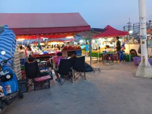 a group of people sitting in chairs at an outdoor market at BEN & LEK GUESTHOUSE in Pattaya South +33 photos