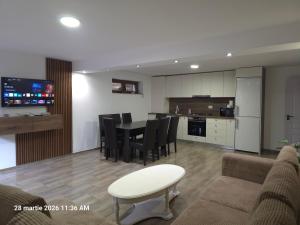 a living room and kitchen with a table and chairs at DIDI Apartament in Craiova