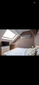 a bedroom with a large bed and a window at Chez mimi et Ludo in Saint-Étienne-au-Mont