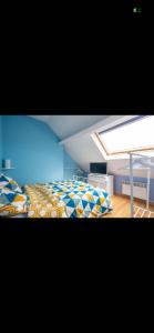 a bedroom with a bed with a blue ceiling at Chez mimi et Ludo in Saint-Étienne-au-Mont