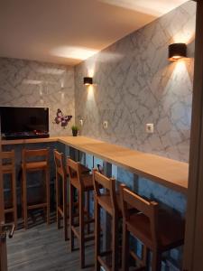 a kitchen with a long bar with wooden chairs at Jardim da Guarda Inglesa in Santa Clara