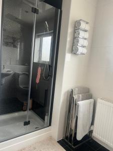 a bathroom with a shower and a sink and towels at Cozy Room at Willow House in Leyland +10 photos