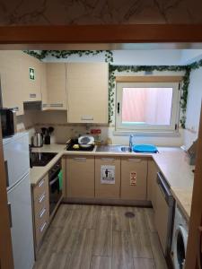a kitchen with wooden cabinets and a sink and a window at Jardim da Guarda Inglesa in Santa Clara