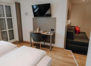 a small room with a desk with a tv on the wall at Zum Bräu-Toni in Dietfurt