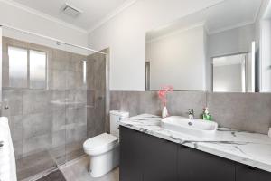 ein Badezimmer mit Waschbecken, Toilette und Dusche in der Unterkunft Stylish Luxury 4BR - Close to Wineries & City in Munno para Downs