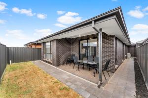 ein Anbau an ein Backsteinhaus mit Terrasse in der Unterkunft Stylish Luxury 4BR - Close to Wineries & City in Munno para Downs