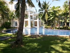 une villa avec piscine et palmiers dans l'établissement 4 BR Pool Villa Hua Hin Blue Lagoon, à Cha Am