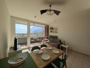 a living room with a table and chairs and a couch at Green Oasis Garda Apartment in Riva del Garda