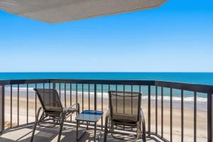 three chairs and a table on a balcony overlooking the beach at Grande Beach Resort in Myrtle Beach +127 photos