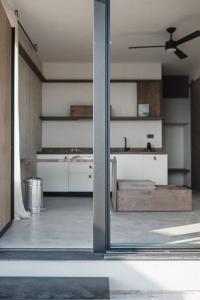 a kitchen with white cabinets and a ceiling fan at Ukino House in Nikiana +28 photos