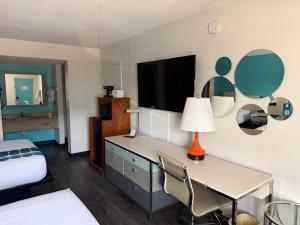 a hotel room with a desk and a tv at Howard Johnson by Wyndham Ft. Myers FL in Fort Myers