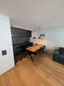 a dining room with a table and a green couch at Ferienwohnung Flumserberg, Liftnähe & Gratis Parkplatz in Flumserberg
