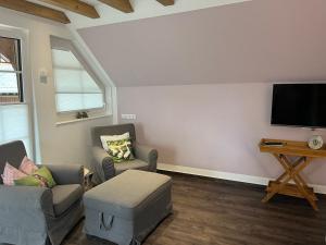a living room with two chairs and a flat screen tv at Tinywohnung in Schluchsee