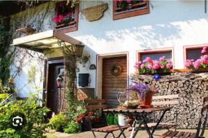 a patio with a table and a building with flowers at Tinywohnung in Schluchsee